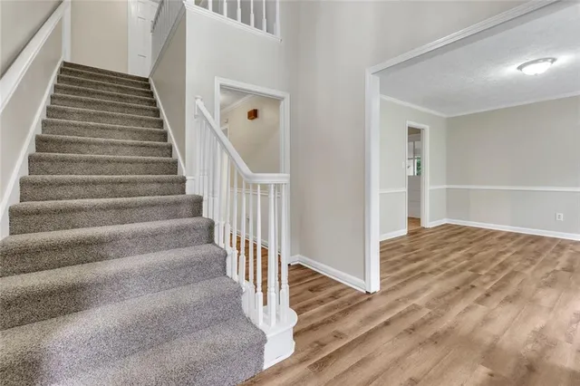 a view of a hallway with wooden floor and entryway