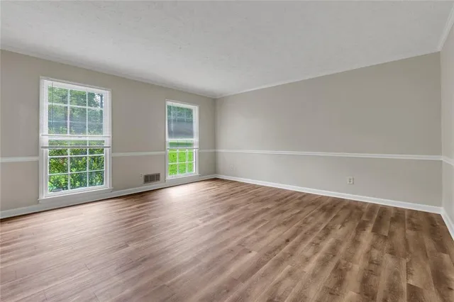 wooden floor in an empty room with a window