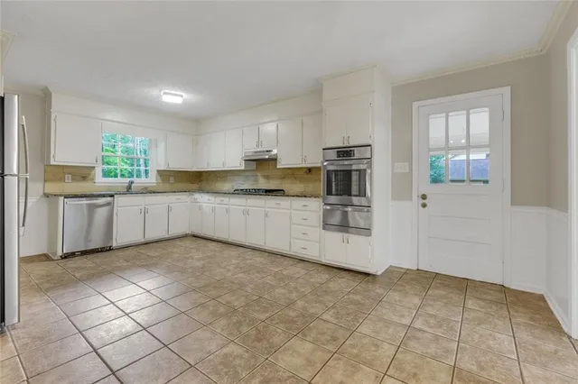 a kitchen with stainless steel appliances a refrigerator sink and cabinets