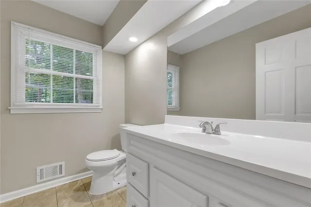 a bathroom with a sink a toilet and a window