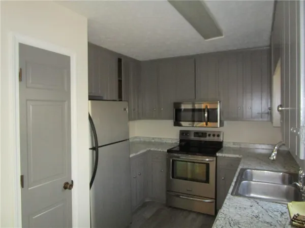 a kitchen with a refrigerator stove and cabinets