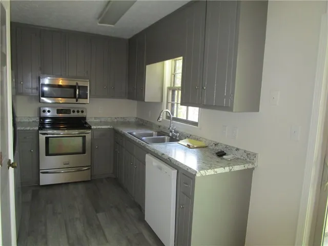 a kitchen with stainless steel appliances granite countertop a sink stove and microwave