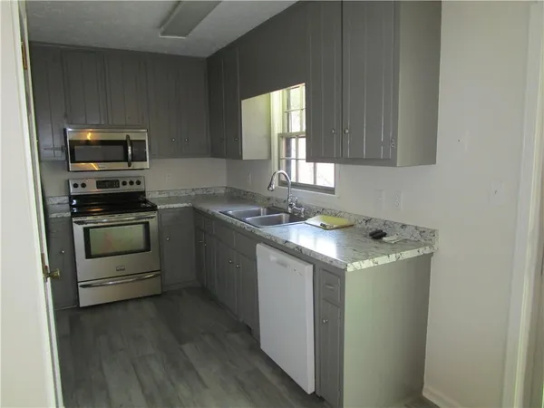 a kitchen with granite countertop a sink and steel appliances