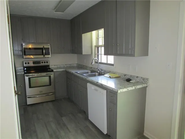 a kitchen with granite countertop a sink and steel appliances