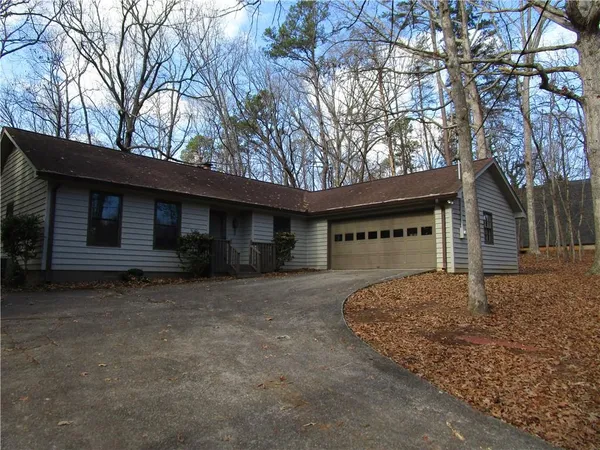 a front view of house with yard and trees in the background