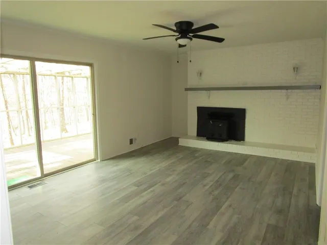 a view of an empty room with a fireplace and a window