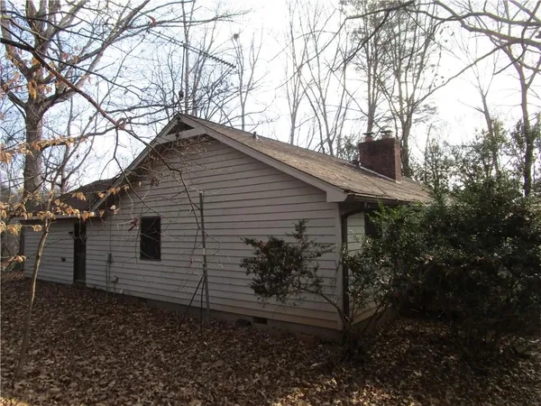 a backyard of a house with lots of plants and trees