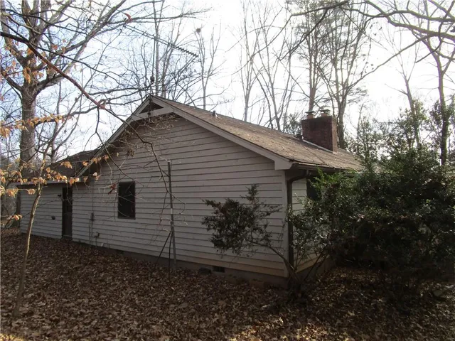 a backyard of a house with lots of plants and trees