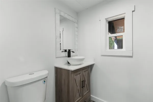a bathroom with a sink a toilet and a mirror