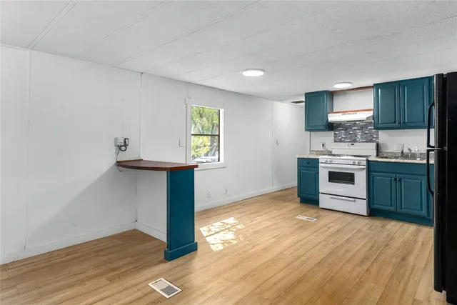 a kitchen with stainless steel appliances granite countertop a stove a sink and a refrigerator