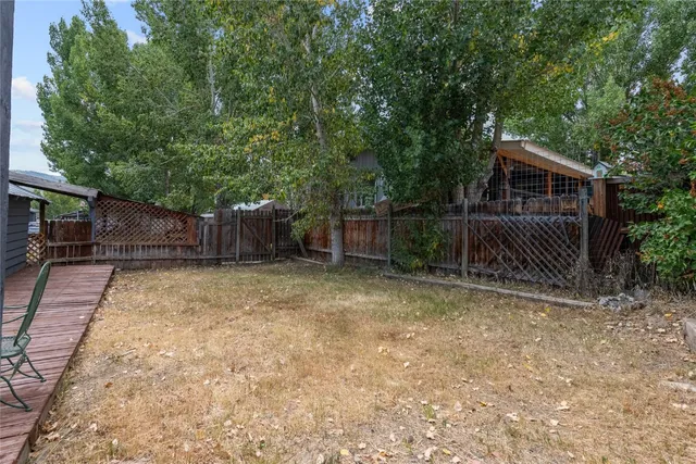 a view of backyard and wooden fence
