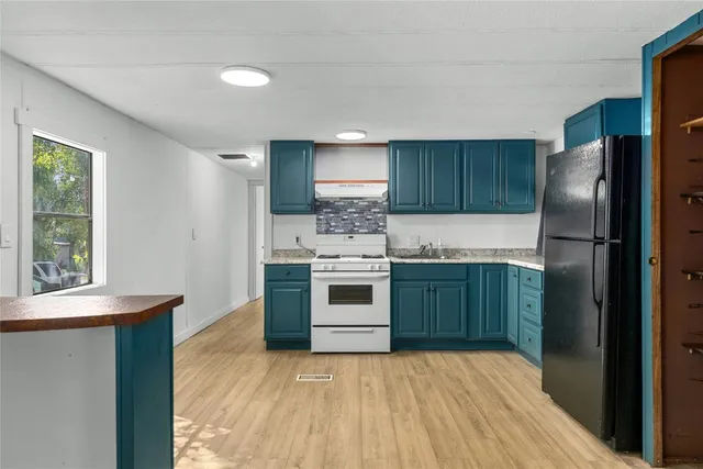 a kitchen with stainless steel appliances kitchen island granite countertop a refrigerator stove and sink