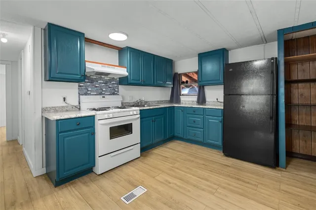 a kitchen with stainless steel appliances granite countertop a refrigerator and a sink