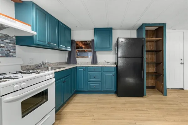 a kitchen with a refrigerator and a stove top oven