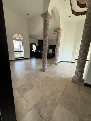 a view of an empty room with a fireplace and a chandelier