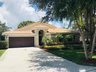 a front view of a house with yard and green space