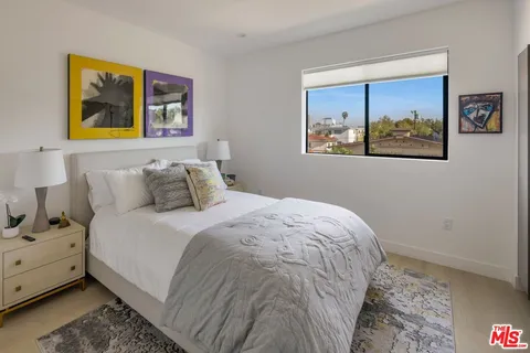 a bedroom with a bed and painting on the wall