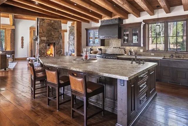 a kitchen with a stove a sink a dining table and chairs