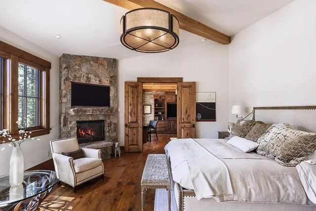 a bedroom with a large bed and a fireplace