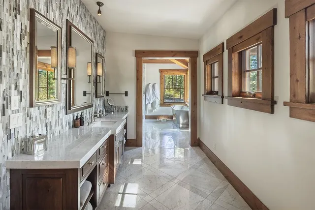 a bathroom with a granite countertop sink a mirror and a bathtub