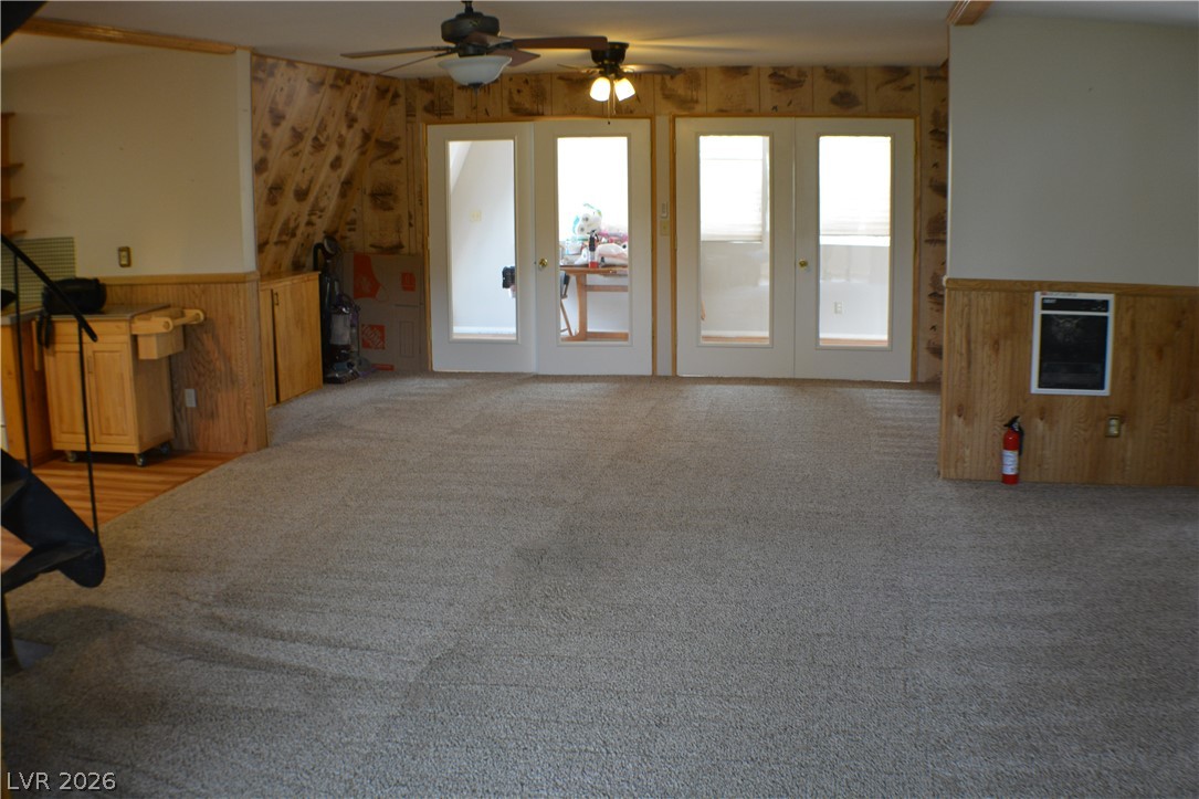 1321 Trout Canyon Road Las Vegas, NV 89124 - Photo 14 of 50 A spacious room features plush carpeting and a pair of French doors leading to another area.