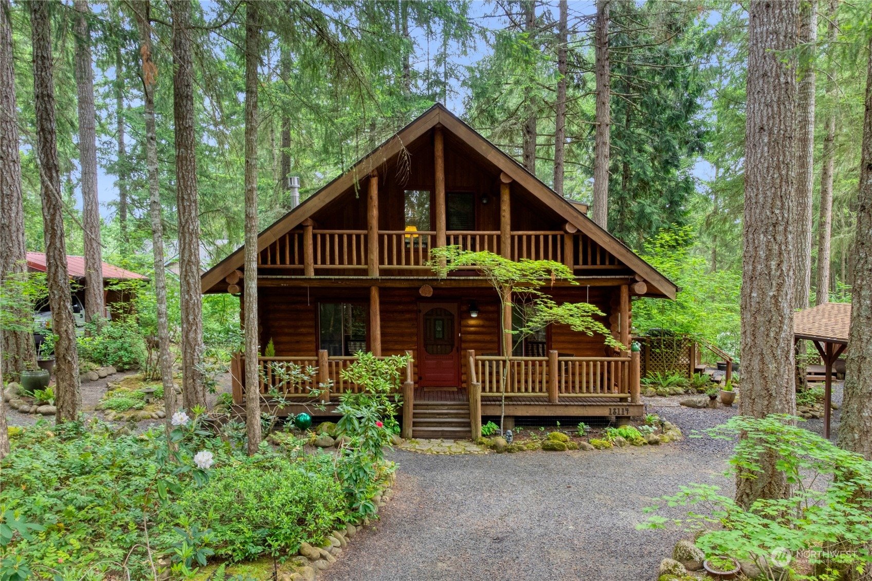 18114 Rampart Drive Southeast Yelm, WA 98597 - Photo 3 of 38 a view of wooden house with a small yard plants and large trees