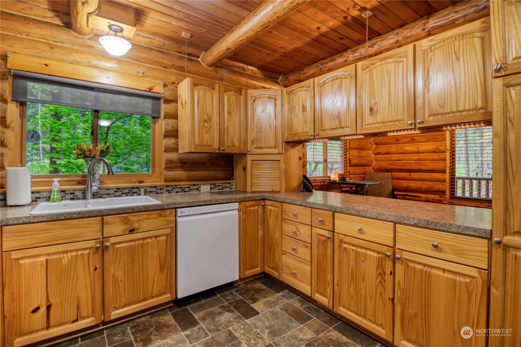 18114 Rampart Drive Southeast Yelm, WA 98597 - Photo 9 of 38 a kitchen with stainless steel appliances wooden cabinets a sink and a large window