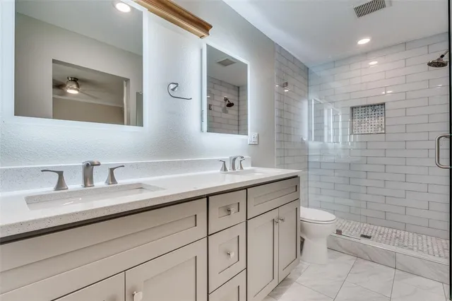 a bathroom with a double vanity sink a toilet and a mirror
