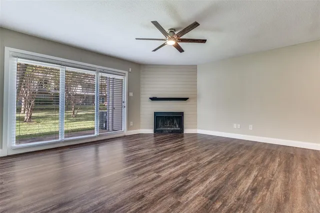 a view of empty room with wooden floor and fireplace