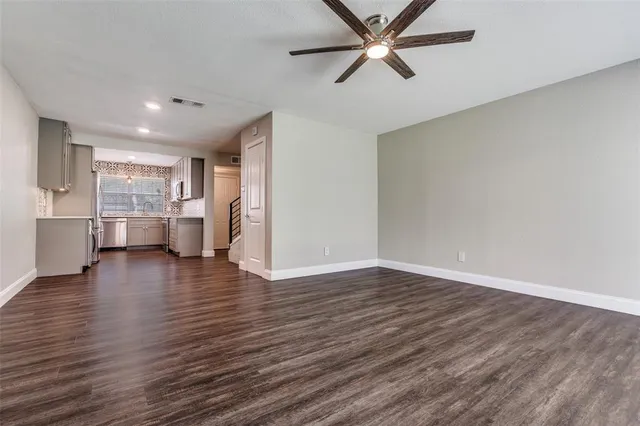 a view of empty room with wooden floor and window