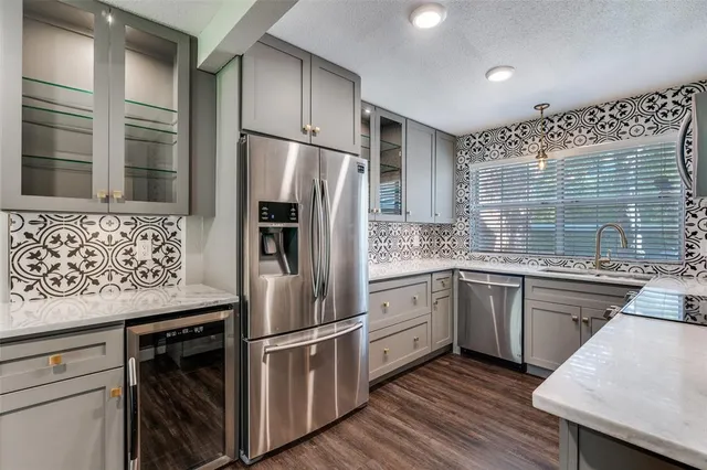 a kitchen with stainless steel appliances white cabinets and wooden floor