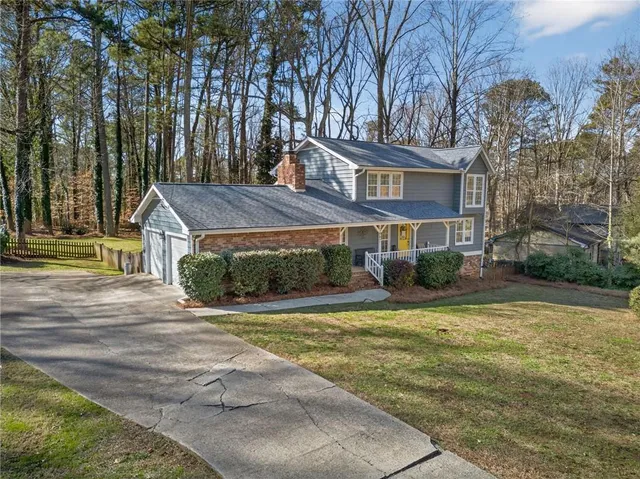 a view of a yard with plants and wooden fence