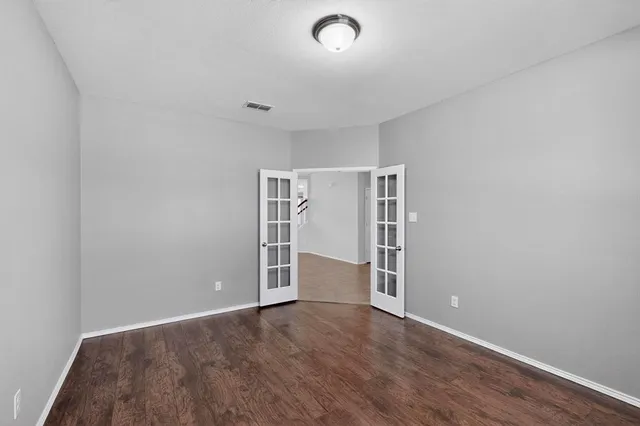 an empty room with wooden floor and closet