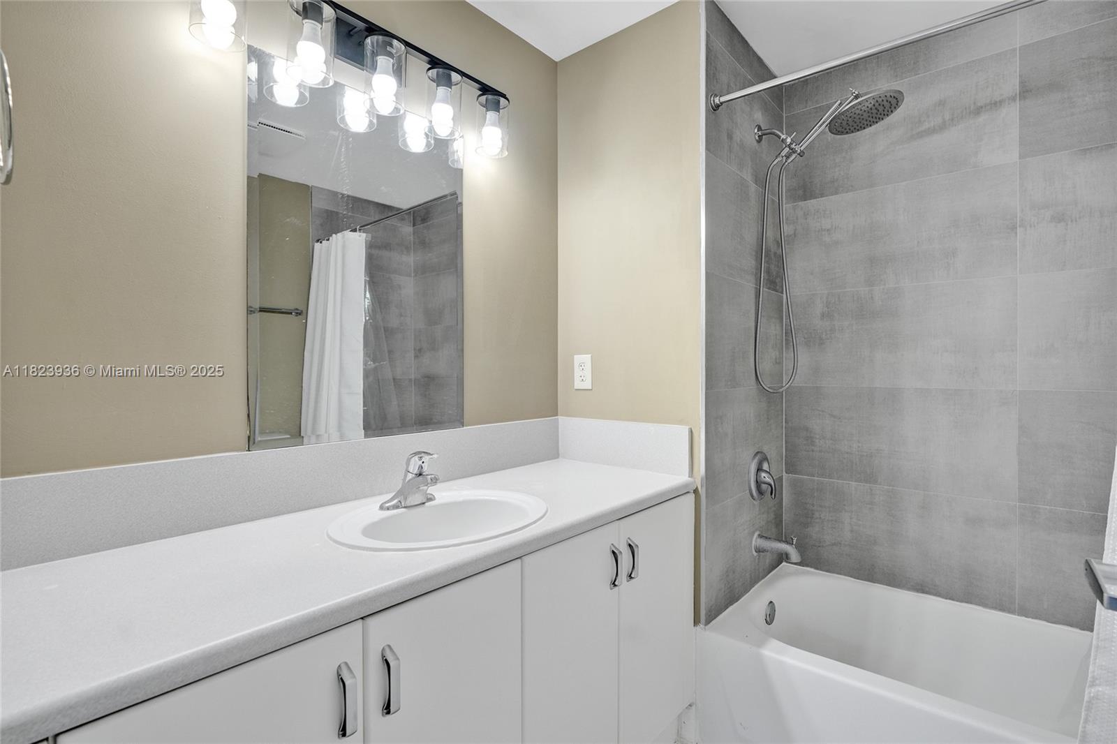 455 Northeast 25th Street, Unit 609 Miami, FL 33137 - Photo 11 of 27 a bathroom with a sink double vanity granite tub and shower