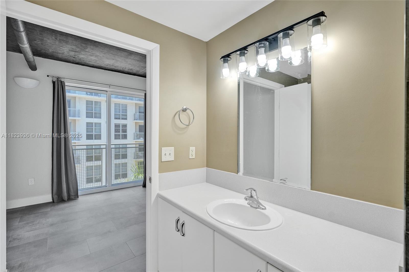 455 Northeast 25th Street, Unit 609 Miami, FL 33137 - Photo 13 of 27 a bathroom with a sink and a mirror