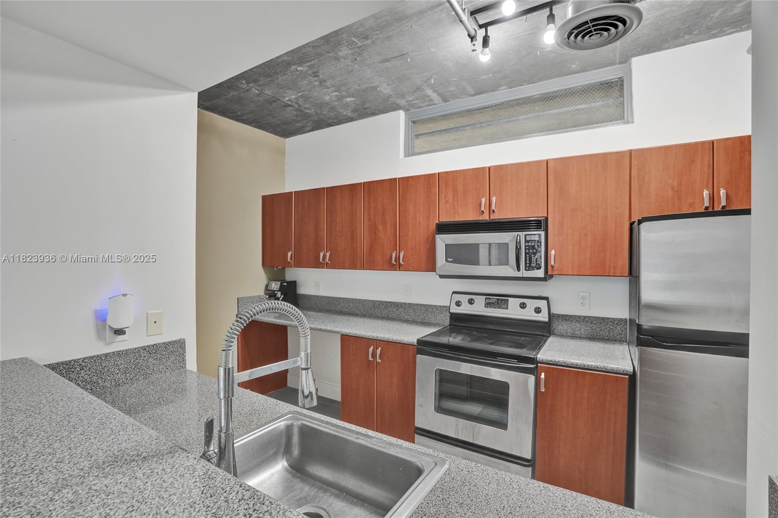 455 Northeast 25th Street, Unit 609 Miami, FL 33137 - Photo 6 of 27 a kitchen with stainless steel appliances granite countertop a stove and a refrigerator