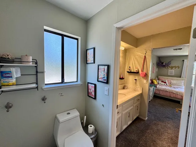 a bathroom with a toilet sink and mirror