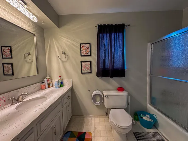 a bathroom with a granite countertop toilet sink and mirror