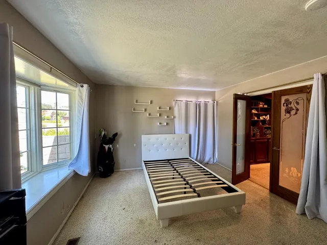 a view of an empty room with a fireplace and a window