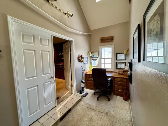 a view of a workspace with furniture and a window