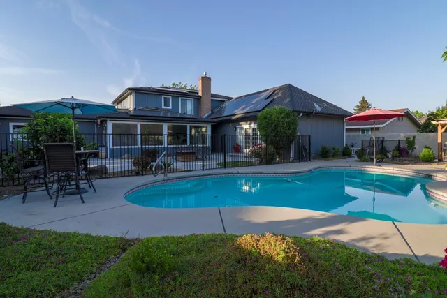 a patio with a table and chairs under an umbrella