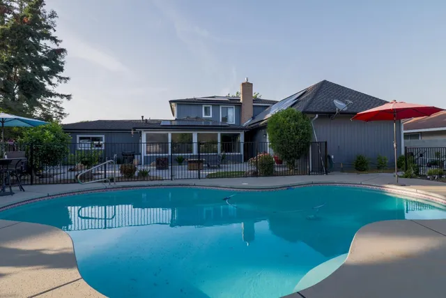 a view of a house with swimming pool and sitting area