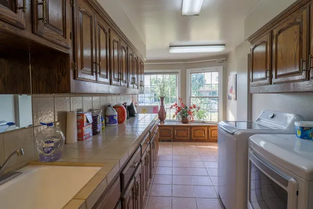 a kitchen with stainless steel appliances granite countertop a sink a stove and cabinets