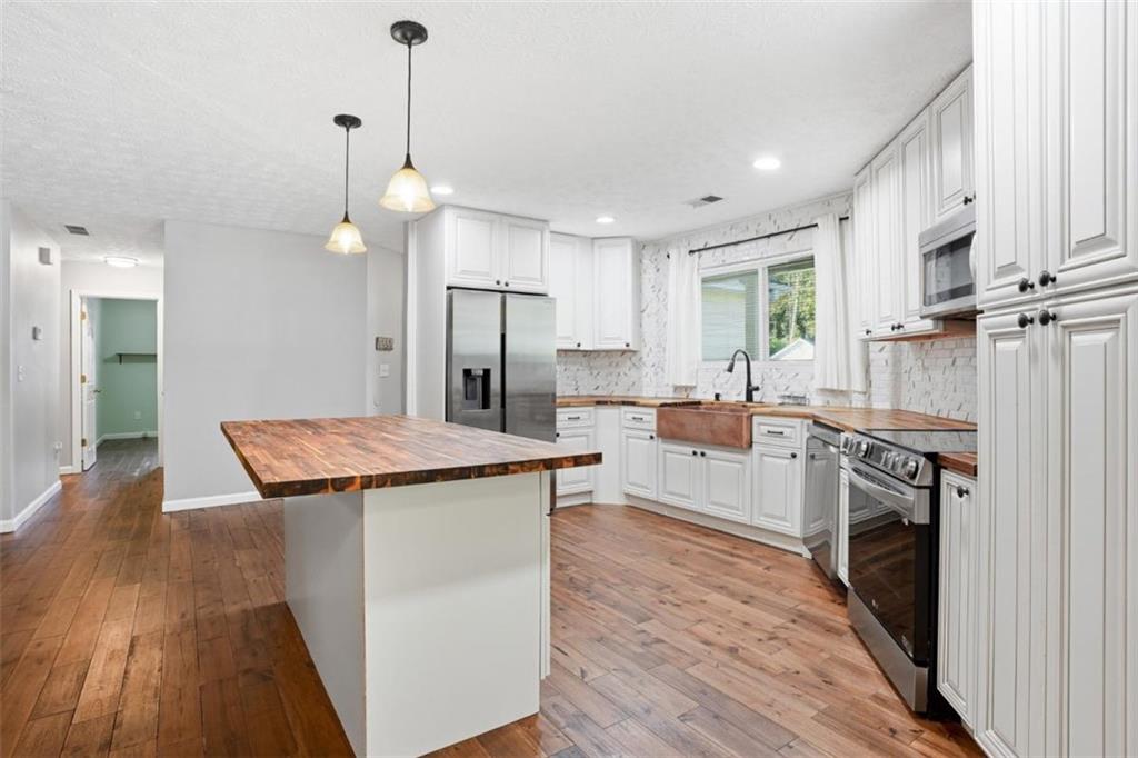 15 Beaverdam Lane Covington, GA 30016 - Photo 8 of 24 a kitchen with stainless steel appliances granite countertop a stove a sink a refrigerator and a wooden floors