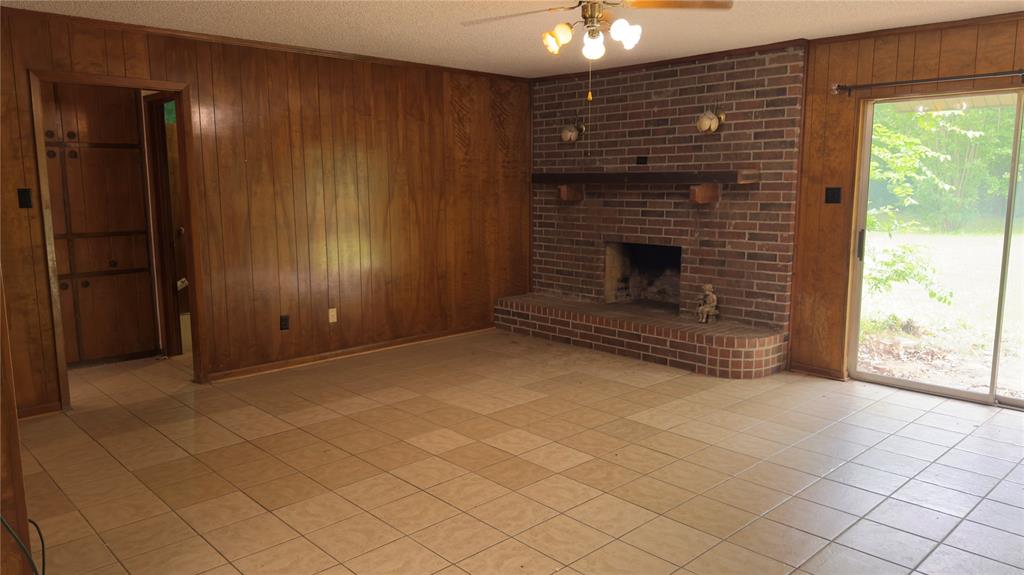 415 Meadowlark Trail Springtown, TX 76082 - Photo 9 of 35 an empty room with windows and fireplace