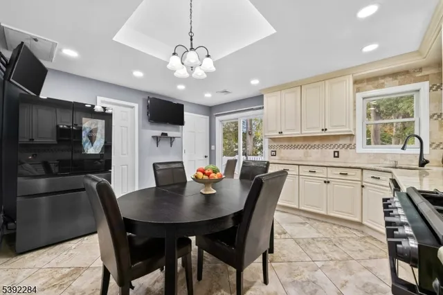 a open kitchen with stainless steel appliances granite countertop a sink a stove a dining table and chairs