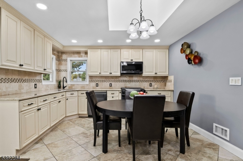 298 4th Avenue Hawthorne, NJ 07506 - Photo 18 of 26 a kitchen with kitchen island granite countertop stainless steel appliances cabinets a dining table and chairs