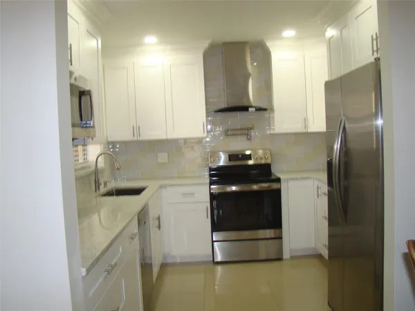 a kitchen with stainless steel appliances granite countertop a refrigerator and a sink