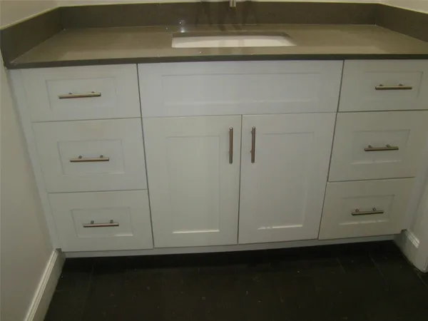 a bathroom with a granite countertop toilet sink and mirror