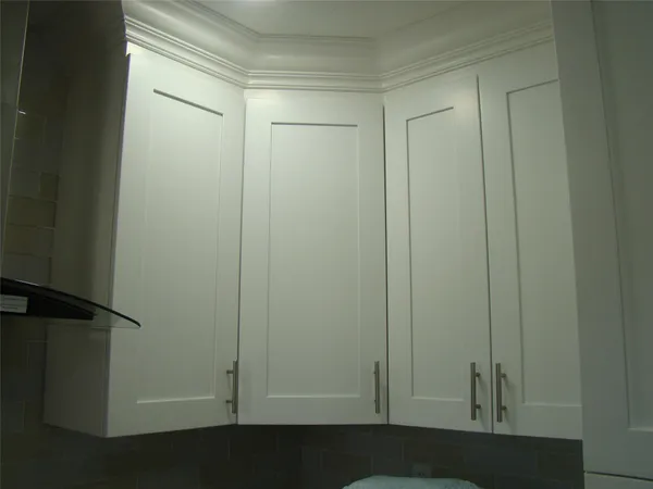 a view of an empty room with wooden floor and closet